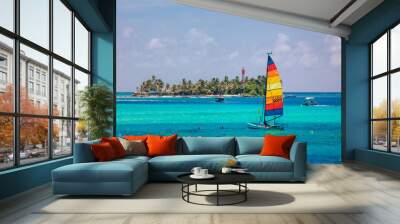 Small colorful sailboat sailing in the blue and transparent waters of the island of San Andres. Wall mural