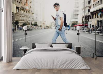 young man using mobile phone in the city of madrid. young boy in the heart of madrid. madrid centro. Wall mural