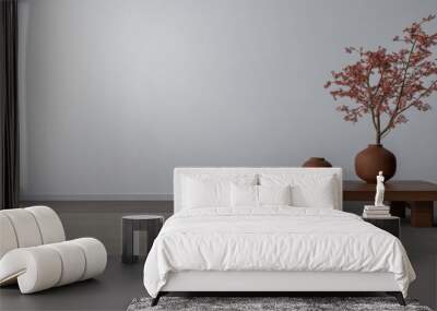 A minimalist living room featuring a wooden table with vases and a decorative plant in a serene, well-lit space Wall mural