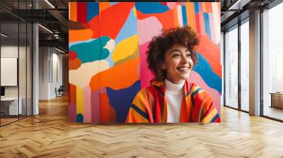 Happy young woman leaning against a colorful wall Wall mural