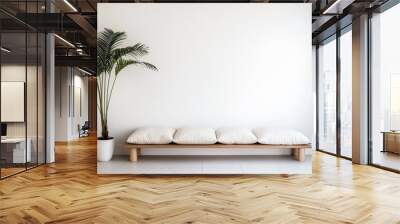 Modern minimalist seating area featuring a wooden bench with cushions and a potted palm plant against a white wall Wall mural