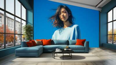 Young Asian woman portrait in bright blue color background Wall mural