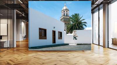 Traditional facade of a house in Teguise, with the church tower in the background. Wall mural