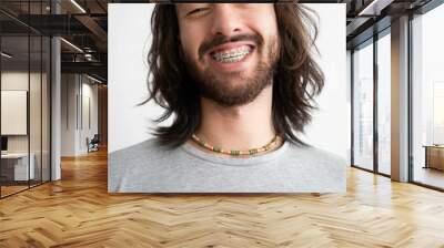 close up of a young latin man with braces wearing a colorful ceramic necklace Wall mural