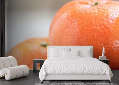 Delicious and juicy tangerines pyramid on spring wooden table with fruit bowl in the background Wall mural