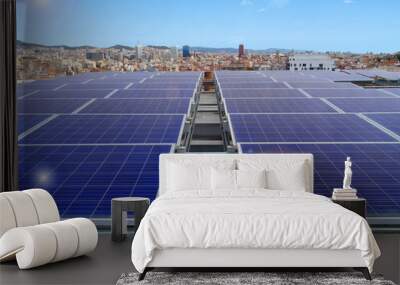 front view of solar panels on a rooftop overlooking the Barcelona skyline on a sunny day with a blue sky and solar glare effects Wall mural