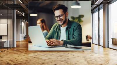 Smiling busy professional business man working on laptop sitting at a coffee shop. Wall mural