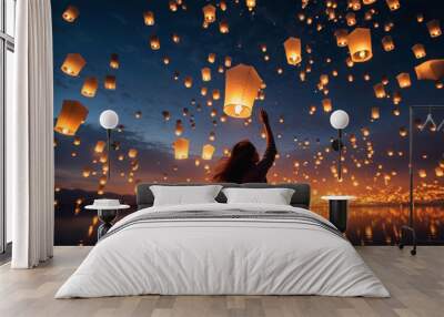 Young woman releasing a sky lantern into the night sky Wall mural