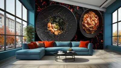 Asian miso soup ,soy sauce, greens and baked salmon pairing with udon and shrimps. On a black stone background, top view Wall mural