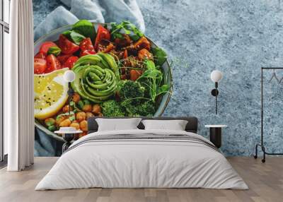 Buddha bowl salad with baked sweet potatoes, chickpeas, broccoli, tomatoes, greens, avocado, pea sprouts on light blue background with napkin. Healthy vegan food, clean eating, dieting, top view Wall mural