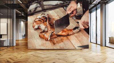 Chef Hands cutting grilled rabbit for steaks with knife on cutting board. Hot Meat dishes Wall mural