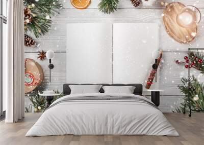 Creative layout made of Christmas tree branches with holiday book, pencil, pine cones, gifts on white background. Xmas and Happy New Year theme, bokeh, sparking, glowing. Flat lay, top view Wall mural