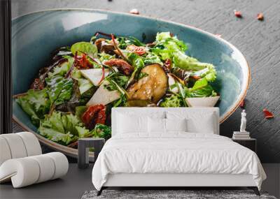 Healthy salad with grilled eggplant, greens, arugula, spinach, lettuce, dried tomatoes and cheese in plate over dark table. Healthy vegan food, clean eating, dieting. Wall mural