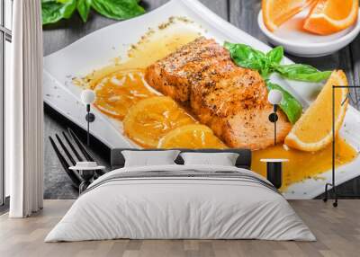 Honey Glazed fillet salmon with orange slices, spices and basil on white plate on dark background. Delicious dish of seafood Wall mural