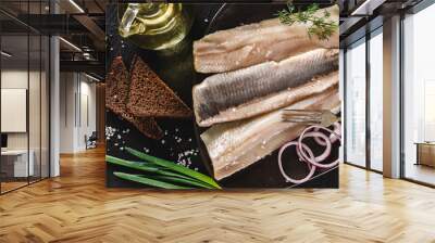 Marinated fillet mackerel or fillet herring fish with spices, greens and slice of bread on plate over dark stone background. Mediterranean food, appetizer, seafood, top view Wall mural