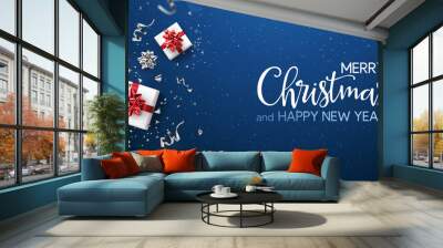 Merry Christmas and New Year text on blue holiday background with red gift boxes, silver fir branches, ribbons, decoration, sparkles, confetti, bokeh, light. Xmas card. Vector Illustration Wall mural