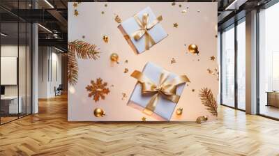 Merry Christmas card made of gold flying decorations, gift boxes, fir branches, snowflakes, sparkles and confetti on light gold background. Xmas and New Year holiday, bokeh, light. Selective focus Wall mural