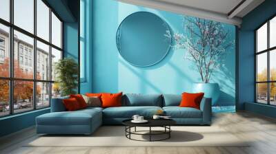 Bright blue room with a round mirror and blooming tree in a decorative pot Wall mural