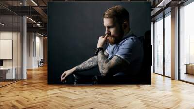 Thoughtful red bearded man studio portrait on dark background Wall mural