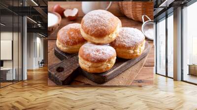 Hanukkah sweet food doughnuts sufganiyot with powdered sugar and fruit jam on a wooden board. Jewish holiday Hanukkah concept. Wall mural