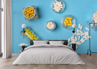 Dietary supplements, vitamins and minerals tablets from above on a blue background. Wall mural