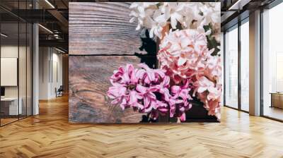 Hyacinths on a wooden background. Bouquet of flowers on a brown table. Wall mural