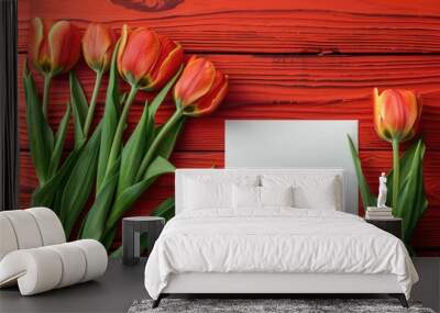 Red tulips with white blank card on a red wooden background Wall mural