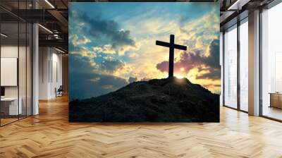 Wooden cross on a hill with dramatic sunset sky. Wall mural