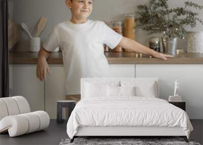 Minimalistic studio photo of eight old caucasian boy wearing in white t-shirt and beige pants for creating mockups for presentation graphic tees and pattern design Wall mural