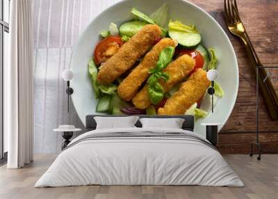 Crispy, fried mozzarella sticks on mixed salad with vinaigrette. Light summer dish. Wall mural