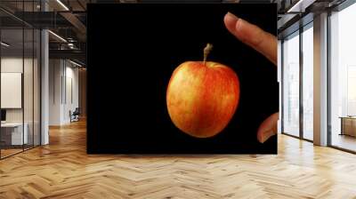 Hand and red apple on black background with levitation effect. Vegan Raw Food Concept           Wall mural