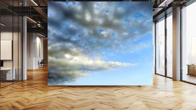 photo of blue sky with white and gray clouds on a summer evening Wall mural