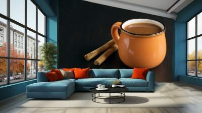 Cocoa in an orange mug on a black background. Wall mural