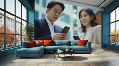 Two Asian business people using smartphone and talking together Wall mural