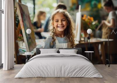 little beautiful girl draws on an easel in an art studio, drawing school, child, childhood, creativity, kid, smiling face, portrait, brush, paints, still life, picture, interior, student, master class Wall mural