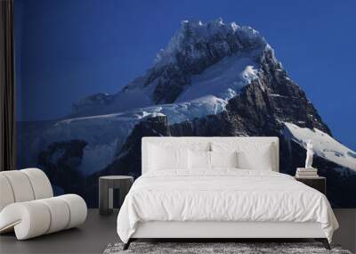 Snowy mountain summit with blue sky Wall mural