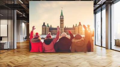 Happy Canadian wearing winter clothes celebrating Christmas holiday at Parliament Hill. People having fun hanging out together walking on city street. Winter holidays and relationship concept Wall mural