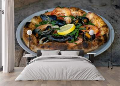 Closeup shot of a delicious pizza with seafood and  mussels on  a plate Wall mural