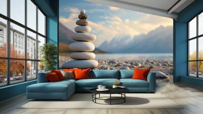 Balanced stone cairn on sandy shores with mountains and a sunset glow in the backdrop Wall mural