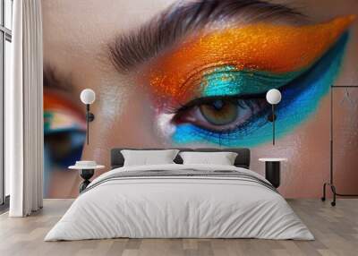 Close up of a woman's face with bright orange, blue and turquoise eyeshadow Wall mural