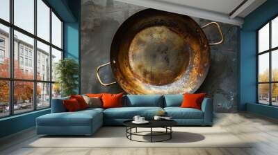 Old copper pan with two handles is lying on a dark background Wall mural