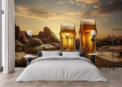 Two glasses of beer on a rocky coast with a golden sunset background Wall mural