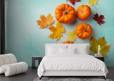 Autumn Thanksgiving background. Pumpkins and maple leaves on turquoise table top view. Wall mural