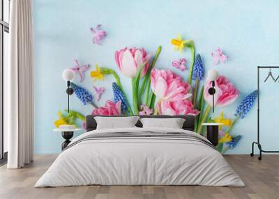 bouquet of beautiful spring flowers on pastel blue table top view. greeting card for international w Wall mural