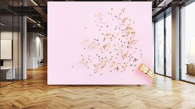 Champagne bottle with confetti stars and party streamers on pink background. Christmas, birthday or wedding concept. Flat lay style. Wall mural