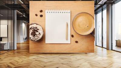 Coffee mug with cupcake, notebook and pencil on rustic table from above, cozy and sweet breakfast, good morning or have a nice day concept Wall mural