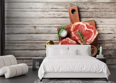 Fresh meat on wooden cutting board top view. Raw beef steak and spices for cooking. Wall mural