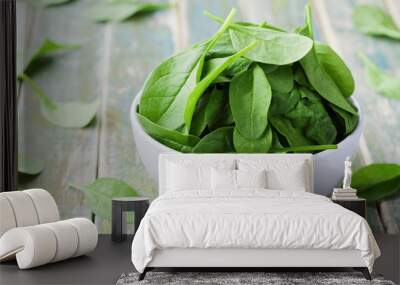 Fresh spinach leaves in bowl on rustic kitchen table, organic food Wall mural