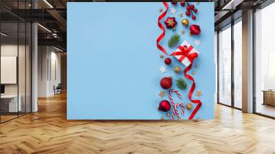 Gift or present box and holiday decorations on light blue background top view. Christmas or New year greeting card. Flat lay. Wall mural