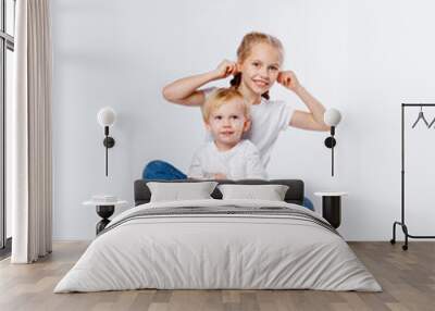 cute brother and sister in blue jeans and t-shirts hugging Wall mural